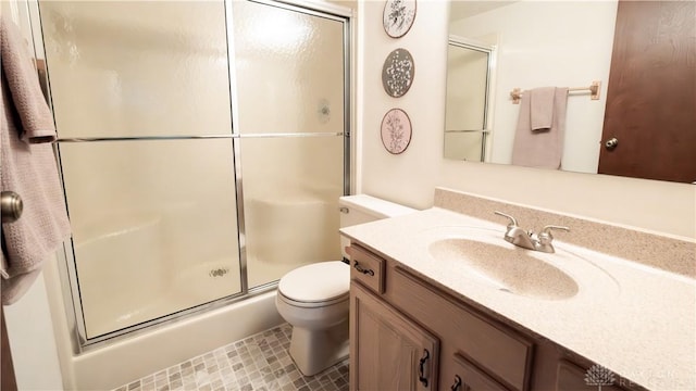 bathroom featuring toilet, a stall shower, vanity, and tile patterned flooring