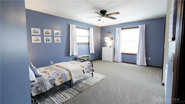 bedroom featuring ceiling fan, baseboards, carpet floors, and a textured ceiling