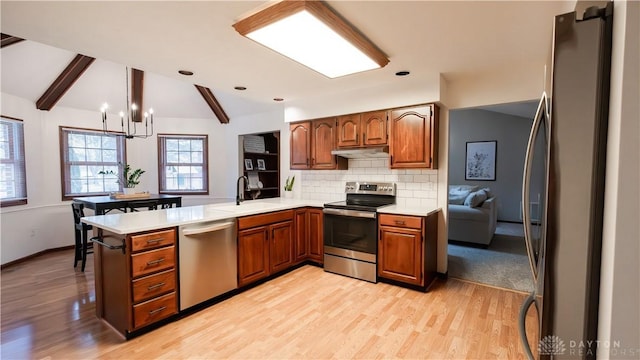 kitchen featuring a sink, tasteful backsplash, stainless steel appliances, light countertops, and vaulted ceiling with beams