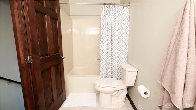 bathroom with toilet and shower / bath combo with shower curtain