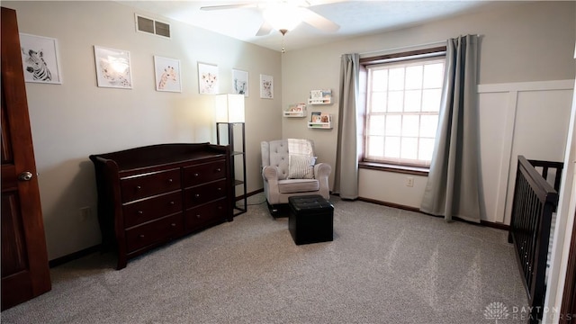 living area with carpet flooring, visible vents, and ceiling fan