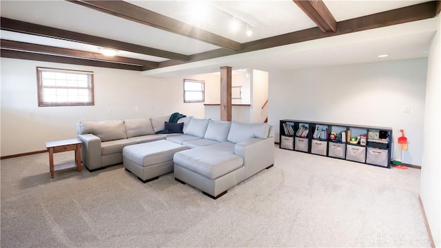 carpeted living area with beamed ceiling, baseboards, and track lighting