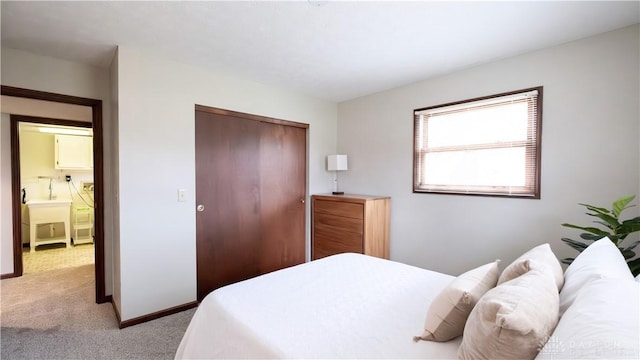 bedroom featuring light carpet, baseboards, and a closet