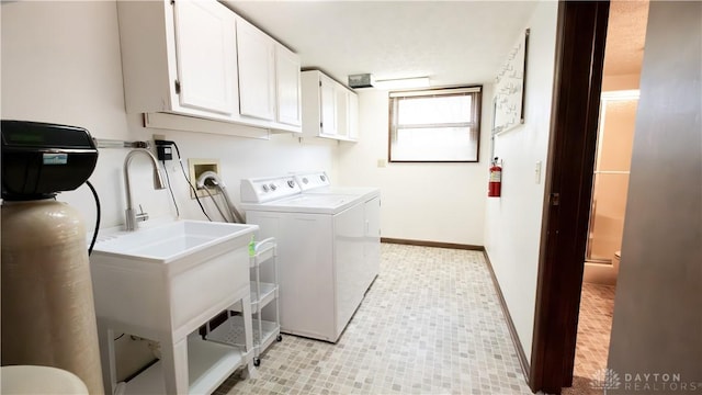 washroom featuring cabinet space, washer and dryer, and baseboards