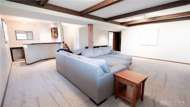 living room featuring baseboards, beam ceiling, light colored carpet, and stairs