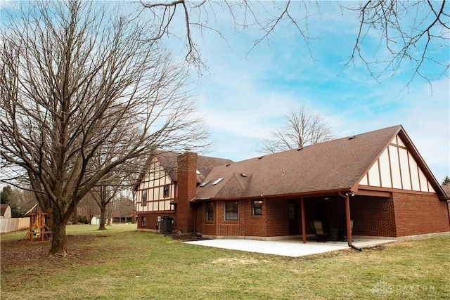 back of property with brick siding, a playground, roof with shingles, a yard, and a patio