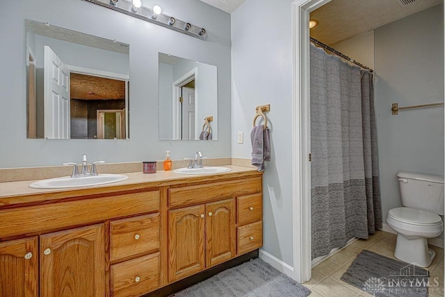 full bathroom with tile patterned floors, toilet, double vanity, and a sink