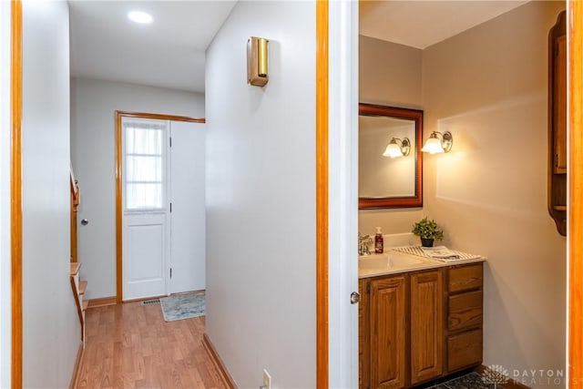 bathroom featuring vanity, baseboards, and wood finished floors