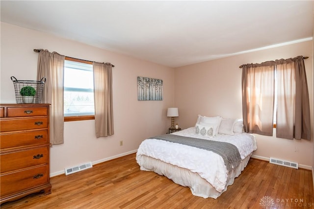 bedroom with visible vents, baseboards, and light wood-style flooring