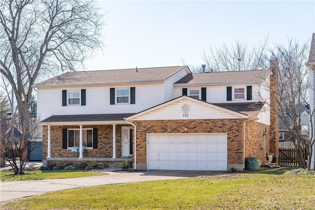 traditional-style home with a front yard, fence, driveway, a porch, and brick siding