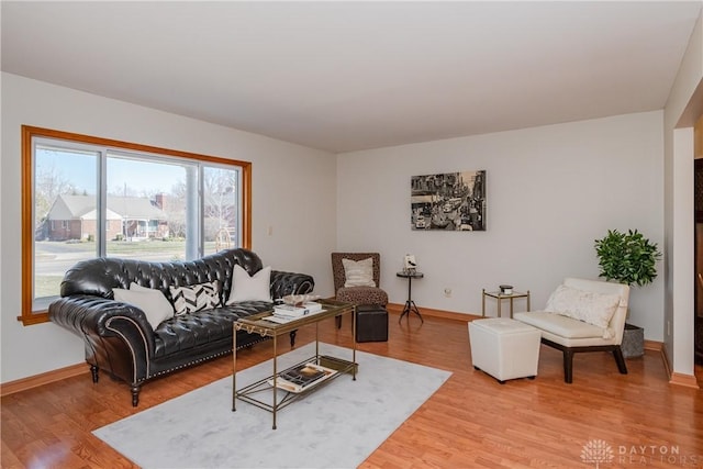 living area with light wood-style flooring and baseboards