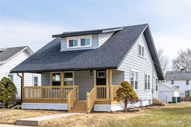 bungalow-style house featuring a porch, a front lawn, and roof with shingles