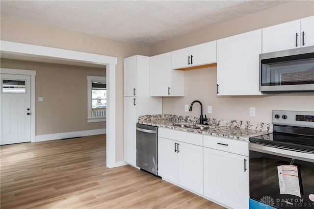 2724 Whittier Ave, Dayton, OH 45420 - kitchen featuring baseboards, light stone counters, white cabinetry, appliances with stainless steel finishes, and a sink