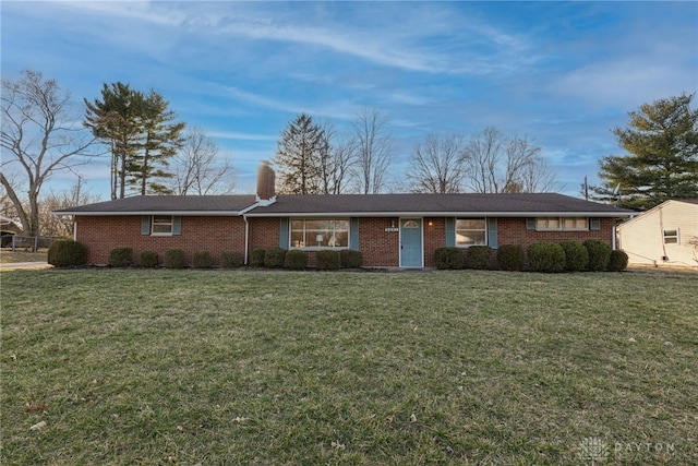 single story home featuring brick siding, a chimney, and a front lawn