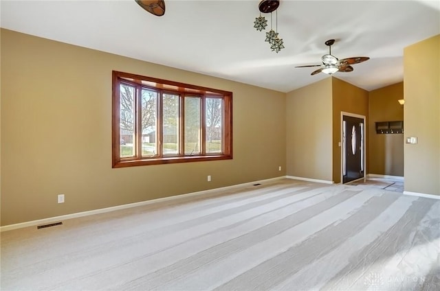 spare room featuring a ceiling fan, lofted ceiling, baseboards, and visible vents