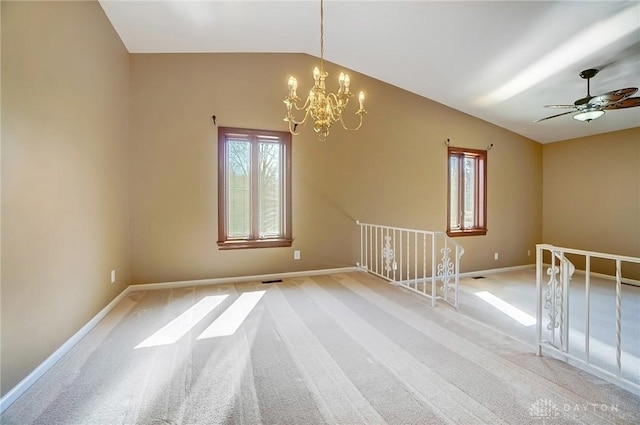 carpeted spare room featuring baseboards, a healthy amount of sunlight, a chandelier, and vaulted ceiling