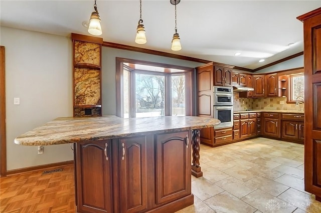 kitchen with open shelves, crown molding, under cabinet range hood, double oven, and tasteful backsplash