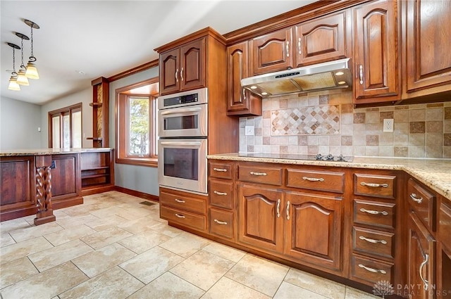 kitchen with pendant lighting, under cabinet range hood, tasteful backsplash, double oven, and black electric cooktop