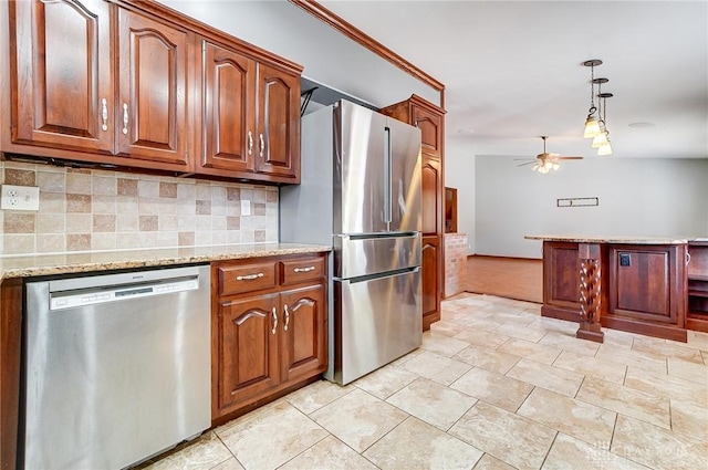 kitchen with backsplash, ceiling fan, light stone counters, appliances with stainless steel finishes, and hanging light fixtures