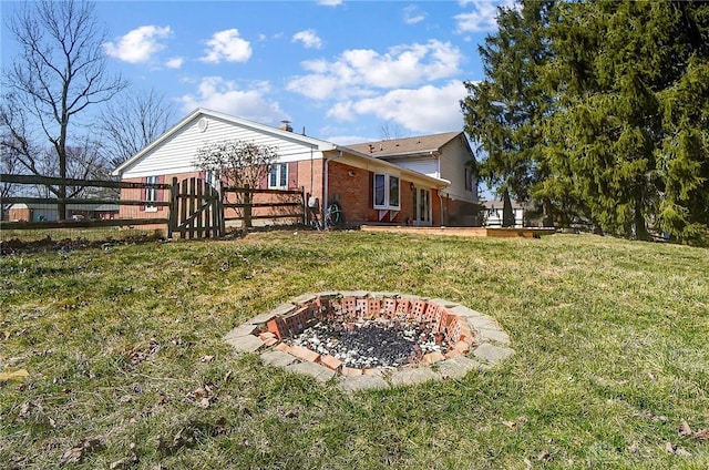 view of yard featuring a gate, a fire pit, and fence