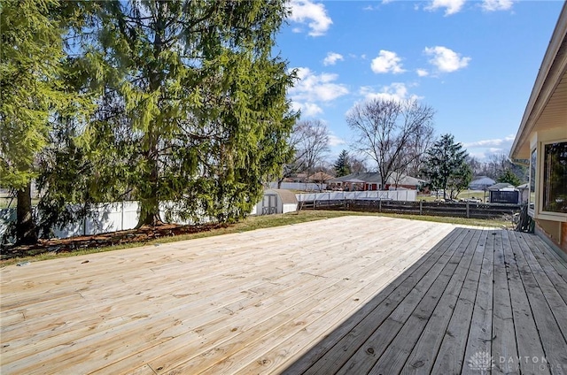 wooden deck with a fenced backyard