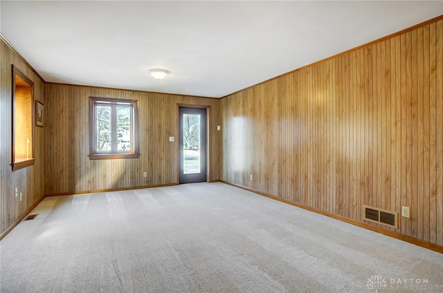 carpeted spare room featuring visible vents and baseboards