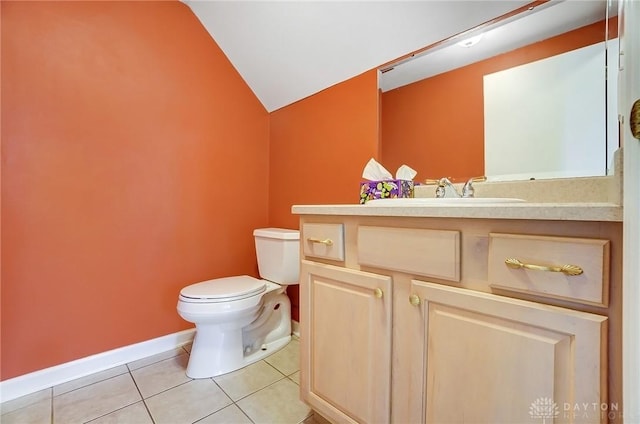 half bath with vanity, baseboards, lofted ceiling, tile patterned floors, and toilet