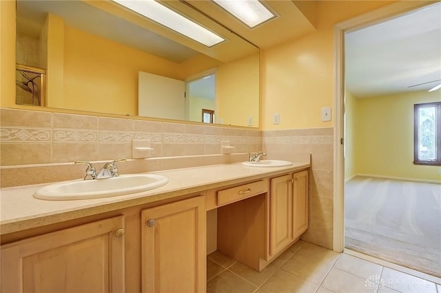 bathroom with a sink, tile walls, double vanity, and tile patterned flooring