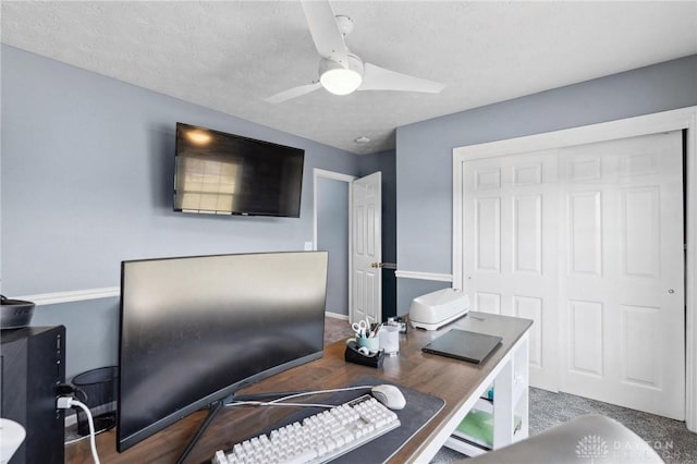 office featuring a textured ceiling, ceiling fan, and carpet flooring