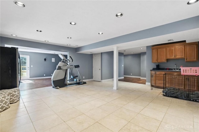 exercise room featuring a sink, baseboards, recessed lighting, and light tile patterned floors