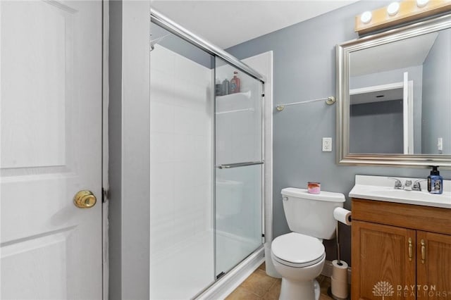 bathroom featuring vanity, a shower stall, toilet, and tile patterned flooring