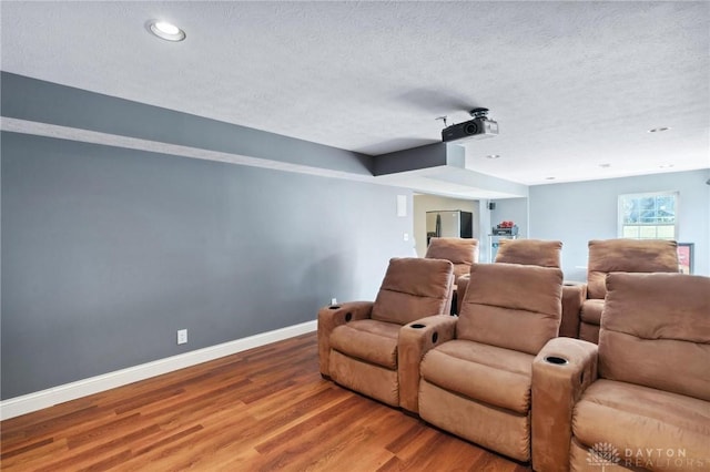 home theater with recessed lighting, wood finished floors, baseboards, and a textured ceiling