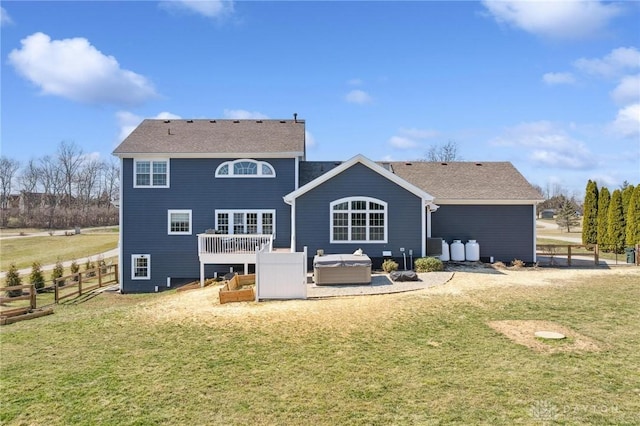 back of property with a lawn, fence, central AC, and a hot tub