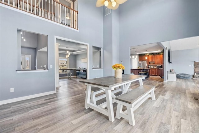 dining room featuring visible vents, baseboards, ceiling fan, and light wood finished floors