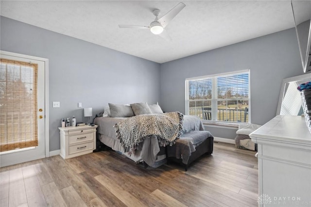 bedroom featuring ceiling fan, baseboards, and wood finished floors