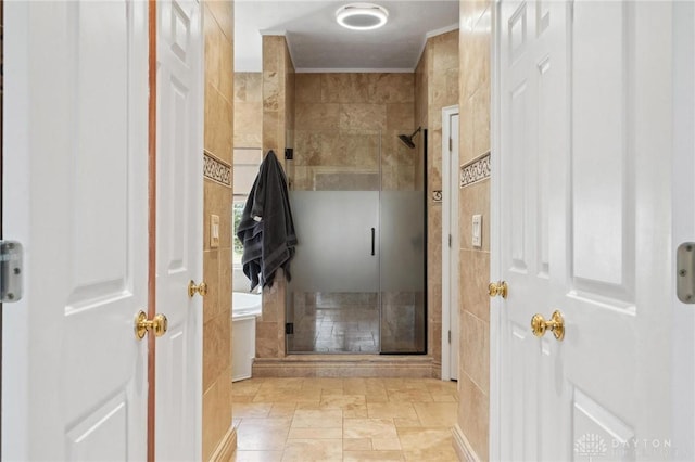 bathroom featuring tile walls, a shower stall, and crown molding