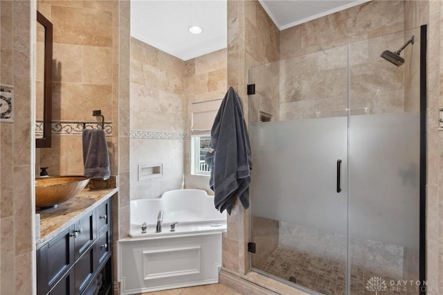 bathroom with vanity, tile walls, a bath, and a shower stall