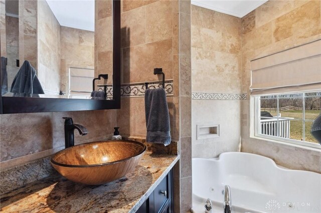 bathroom featuring decorative backsplash, a jetted tub, tile walls, and vanity