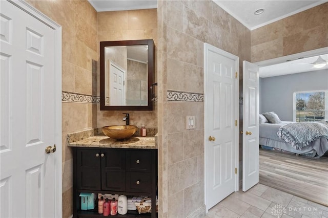 bathroom with vanity, tile walls, ensuite bathroom, and tile patterned flooring