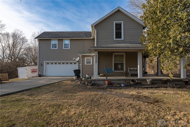 traditional home with a front yard, a porch, concrete driveway, and an attached garage