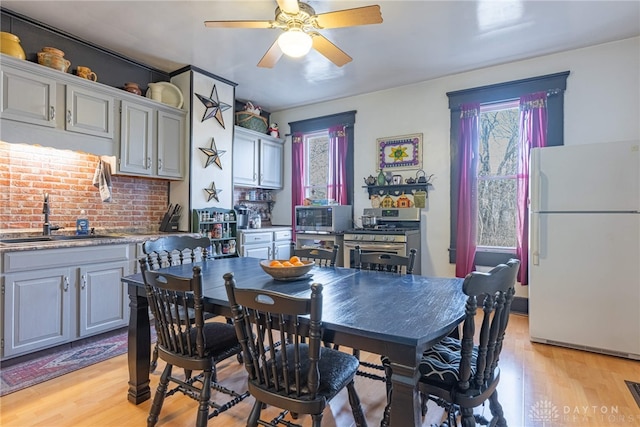 dining room with light wood finished floors and a ceiling fan