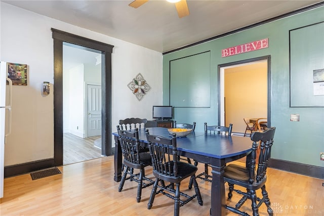 dining space featuring baseboards, light wood-style floors, visible vents, and ceiling fan