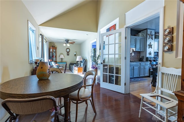 dining room with dark wood-style floors, ceiling fan, and vaulted ceiling