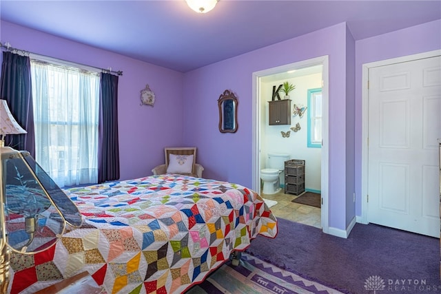 bedroom with ensuite bath, carpet flooring, and baseboards