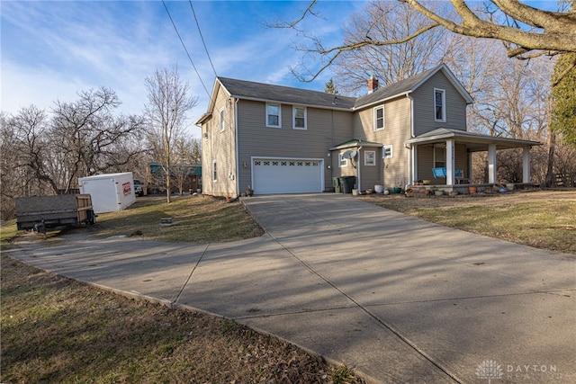 view of front of property with a front yard, a porch, an attached garage, a chimney, and concrete driveway