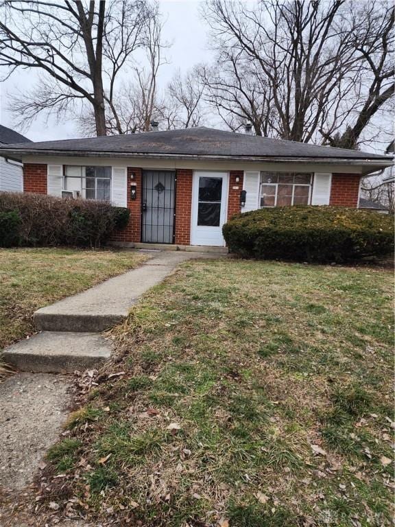 view of front of property with brick siding and a front lawn