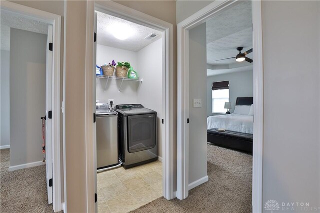 clothes washing area with light carpet, laundry area, and separate washer and dryer