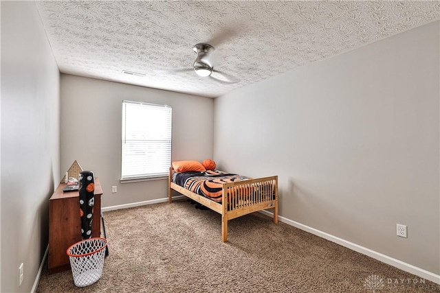 bedroom with a ceiling fan, carpet, visible vents, baseboards, and a textured ceiling