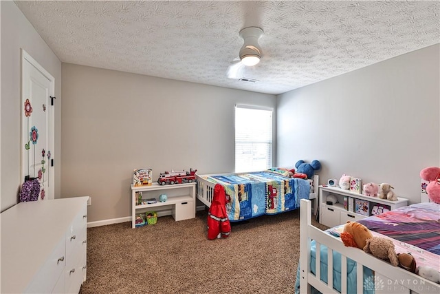 carpeted bedroom with visible vents, a textured ceiling, and baseboards