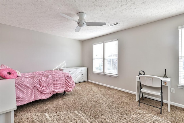 bedroom with visible vents, baseboards, ceiling fan, carpet flooring, and a textured ceiling